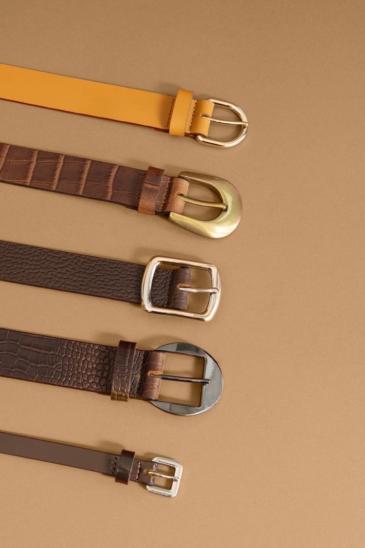 Five men's leather belts with different leather textures and buckle styles